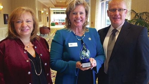 Lisa-Marie Haygood (center) of Cherokee County was congratulated by county School Board Chair Kyla Cromer (left) and Superintendent Brian V. Hightower (right) for winning the Georgia School Public Relations Association’s 2016 Outstanding Leadership in School-Community Relations award. Haygood lost her job this weekend as head of the state PTA organization in an apparent power struggle.