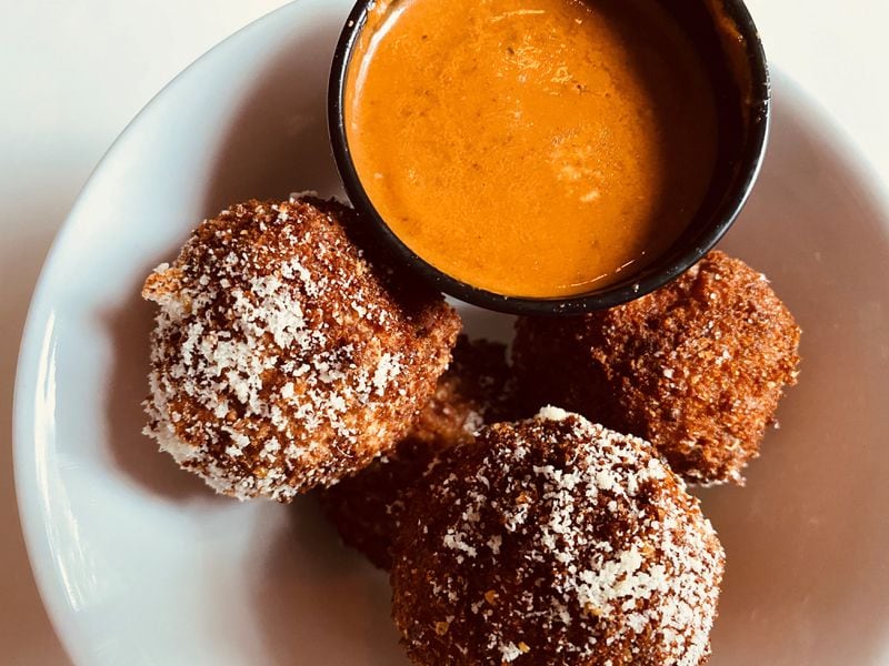 This order of arancini from Piastra is accompanied by sun-dried tomato coulis. Bob Townsend for The Atlanta Journal-Constitution
