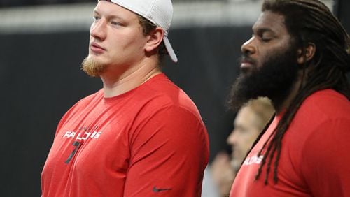 Falcons offensive tackle Kaleb McGary (left), recovering from heart surgery, watches from the sidelines as his team prepares to play the New York Jets.   Curtis Compton/ccompton@ajc.com