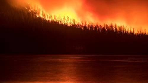 A fire burns next to Lake McDonald in Glacier National Park in northwest Montana. The fire, which was started by lightning on Saturday night, has forced the evacuation of the Lake McDonald Lodge and a nearby campground. (Chris Peterson/Hungry Horse News via AP)