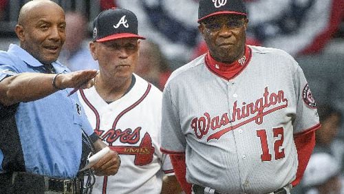 Umpire C.B. Bucknor talking with managers Brian Snitker and Dusty Baker before Tuesday’s game—and before he blew a call at the end. (AP Photo)