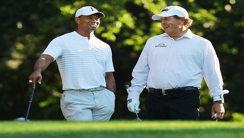 Tiger Woods and Phil Mickelson share a laugh on the 11th tee while playing a practice round for the Masters at Augusta National Golf Club on Tuesday, April 3, 2018, in Augusta, Ga.  (Curtis Compton/Atlanta Journal-Constitution/TNS)