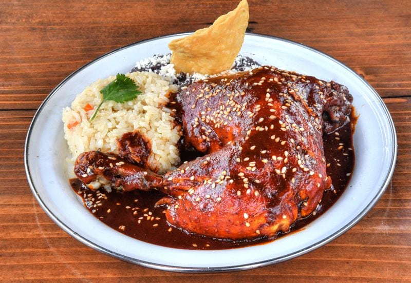Antiguo Lobo's Pollo al Mole, with mole poblano, rice, refried black beans, toasted sesame seeds. (Chris Hunt for The Atlanta Journal-Constitution)