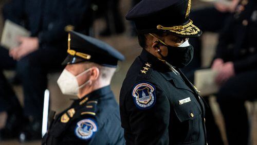 Yogananda D. Pittman, the acting chief of the Capitol Police, pays respects to Officer Brian Sicknick, who died after injuries sustained during the attack Jan. 6., in the Capitol Rotunda. Two men have been charged with assault on Sicknick, although authorities are not certain whether their actions caused his death.(Erin Schaff/The New York Times)