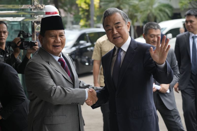 Indonesian President-elect and current Defense Minister Prabowo Subianto, left, greets Chinese Foreign Minister Wang Yi in Jakarta, Indonesia, Thursday, April 18, 2024. The Chinese and Indonesian foreign ministers called for an immediate and lasting cease-fire in Gaza after a meeting in Jakarta on Thursday, condemning the humanitarian costs of the ongoing war that has killed tens of thousands of Palestinians. (AP Photo/Achmad Ibrahim)