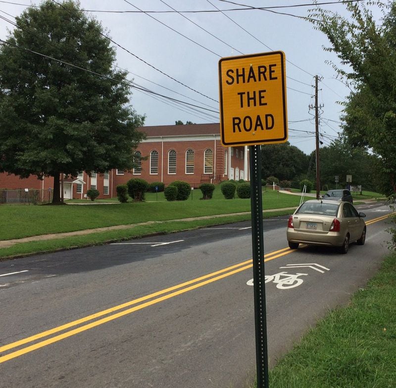 A sign urges motorists to share the road after protected bike lanes (to the left) were scraped up on the request of Shiloh Missionary Baptist Church, a historic congregation near Morehouse College. (Photo by Bill Torpy)