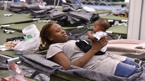 Markita Riley and her 2-month-old daughter Amaris from Brunswick, Ga., prepare to spend the night in a Red Cross shelter in Macon on Friday, Oct. 7, 2016, as Hurricane Matthew hits the coast. BRANT SANDERLIN/BSANDERLIN@AJC.COM