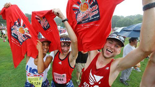 070415 ATLANTA: Max Rabin (from left), Adam Burkley and Hayden Cox, from Johns Creek, celebrate with their t-shirts in Piedmont Park after finishing the AJC Peachtree Road Race on Saturday, July 4, 2015, in Atlanta. Curtis Compton / ccompton@ajc.com