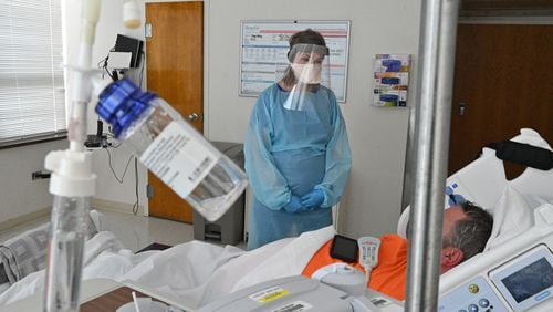 Registered ICU nurse Katie Van Hook checks on a COVID-19 patient at Memorial Health's Heart and Vascular Institute in Savannah. (Hyosub Shin / Hyosub.Shin@ajc.com)