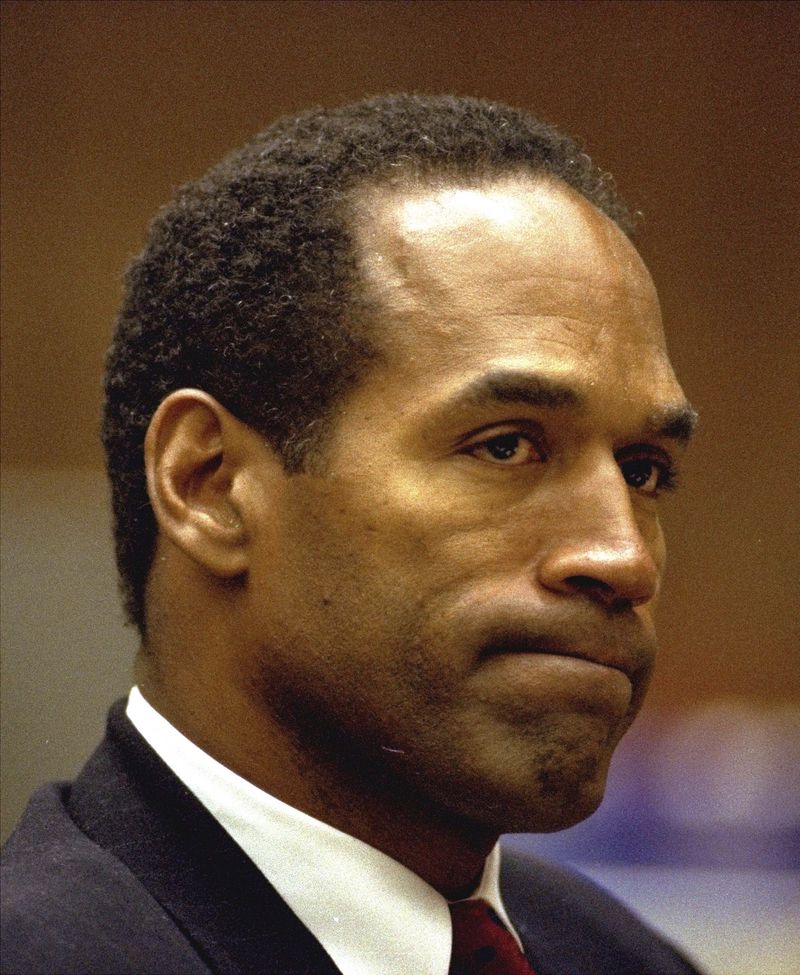 FILE - O.J. Simpson bites his lip Friday, July 8, 1994, as he listens to Dr. Irwin L. Golden, a medical examiner, describe the extent of Nicole Simpson Brown's wounds during testimony in Los Angeles Criminal Courts. Simpson, the decorated football superstar and Hollywood actor who was acquitted of charges he killed his former wife and her friend but later found liable in a separate civil trial, has died. He was 76. (AP Photo/Eric Draper, File)