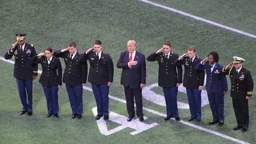 ROTC cadets from Georgia (left) and Alabama escorted President Trump onto the field at Mercedes-Benz Stadium. AJC photo: Hyosub Shin