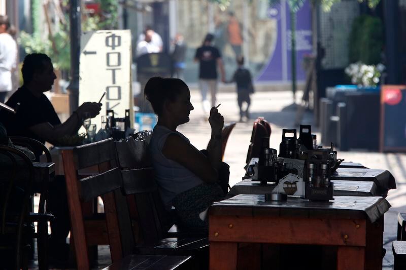 People sit in a restaurant in a street in the Old Bazaar, a day after the presidential and parliamentary elections, in Skopje, North Macedonia, on Thursday, May 9, 2024. North Macedonia elected its first woman president Wednesday as the governing Social Democrats suffered historic losses in twin presidential and parliamentary elections. (AP Photo/Boris Grdanoski)