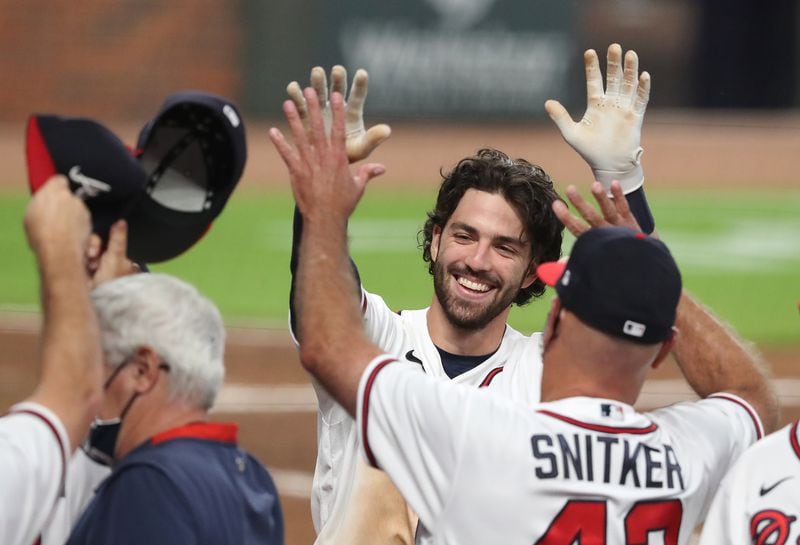 Braves shortstop Dansby Swanson gets a double high five from manager Brian Snitker after hitting a 2-RBI walk off home run to beat the Washington Nationals 7-6 during the 9th inning in a MLB baseball game on Monday, August 17, 2020 in Atlanta.    Curtis Compton ccompton@ajc.com