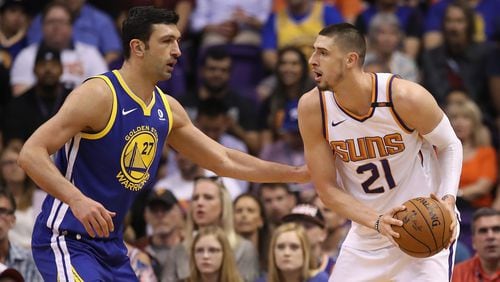 Alex Len of the Phoenix Suns looks to pass around Zaza Pachulia of the Golden State Warriors during the first half of the NBA game at Talking Stick Resort Arena on April 8, 2018 in Phoenix, Arizona.