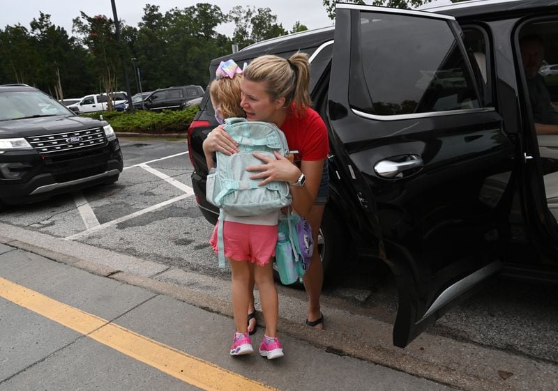 In this file photo, Tiffany Wolfe-Bokey sends her daughter Kendra, kindergartener, off to the first day of school at Jackson Elementary School in Lawrenceville. Students are required to wear masks. Hyosub Shin / Hyosub.Shin@ajc.com)