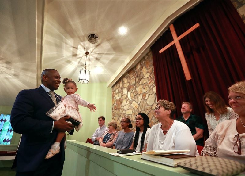 Reverend Tony Lowden and his daughter Tabitha greet visitors in the sanctuary of Maranatha Baptist Church before President Jimmy Carter leads Sunday school and Lowden leads the worship service on June 9. Maranatha associate member Doug Unger, who helped bring Lowden to the church, says, “I just thought he would bring all kind of different energy. I really thought Tony would be somebody that we all would like to hear, because he would bring a fresh perspective to Maranatha.”