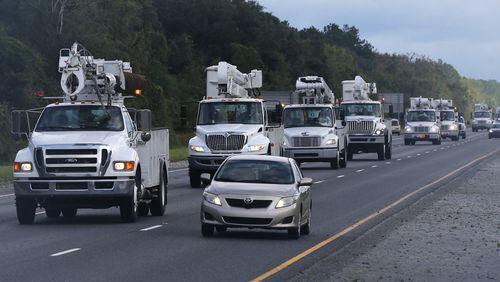A fleet of power trucks heads south on I-95 near Jesup Saturday to begin restoring power in the aftermath of Hurricane Matthew. Curtis Compton /ccompton@ajc.com