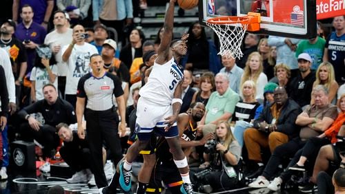 Minnesota Timberwolves guard Anthony Edwards (5) gets past the Phoenix Suns defense for a dunk during the second half of Game 4 of an NBA basketball first-round playoff series Sunday, April 28, 2024, in Phoenix. The Timberwolves won 122-116, taking the series 4-0. (AP Photo/Ross D. Franklin)