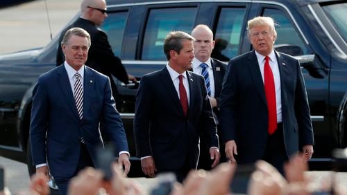 Georgia Gov. Brian Kemp, center, walks with President Donald Trump, right, and U.S. Sen. David Perdue as Trump arrives for a rally Sunday, Nov. 4, 2018, in Macon, Ga. (AP Photo/John Bazemore)