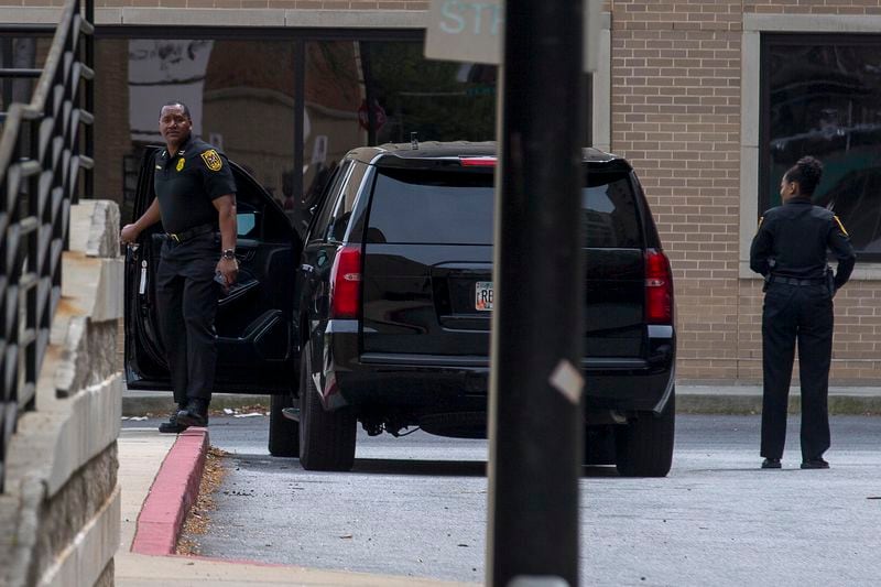 Two police officers prepare to enter Grady Memorial Hospital on Thursday. Two police officers were shot in Henry County and were taken to Grady for treatment. 