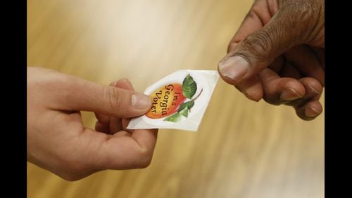 <p> A poll worker hands a voter a, "I'm a Georgia voter," sticker after casting her ballot in Georgia's primary election at Chase Street Elementary in Athens, Ga., Tuesday, May 22, 2018. (Joshua L. Jones/Athens Banner-Herald via AP) </p>