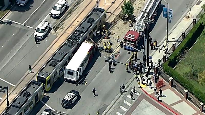 In this aerial still image provided by KABC-TV, firefighters respond to the scene of an accident where a shuttle bus collided with a Metro light rail train on Tuesday, April 30, 2024, in Los Angeles. (KABC via AP)