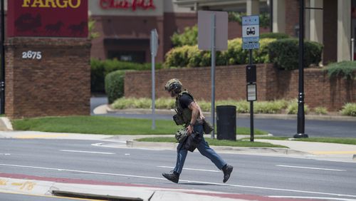 Police officers survey the scene at a Wells Fargo Bank, Friday, July 7, 2017 in Marietta, Ga.(AP Photo/Mike Stewart)