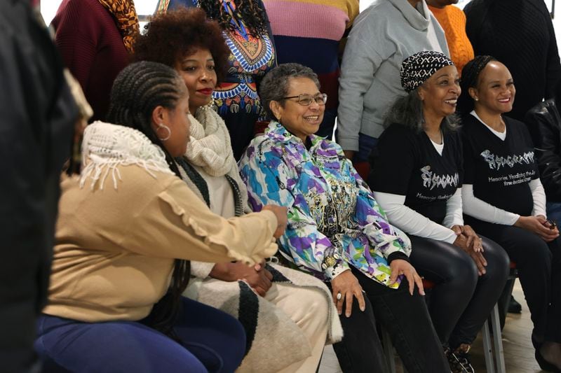 Photographer Susan “Sue” Ross (center) smiles as she takes a photograph with fellow Sistagraphy members at the artist talk for their exhibit “I Wonder As I Wander” on Saturday, Jan. 20, 2024. (Natrice Miller/ Natrice.miller@ajc.com)