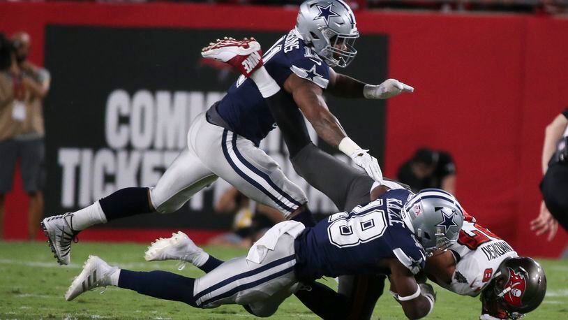 Tampa Bay Buccaneers tight end Rob Gronkowski (87) is taken down by Dallas Cowboys safety Damontae Kazee (18), bottom and linebacker Micah Parsons (11) during the first quarter at Raymond James Stadium, Thursday, Sept. 9, 2021, in Tampa, Florida. (Dirk Shadd/Tampa Bay Times/TNS)