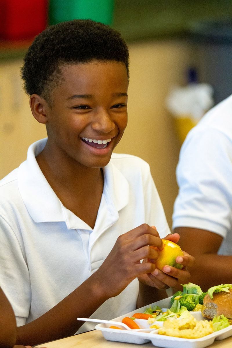 Drew Charter School student Isaiah Rashid peals an orange while eating a school lunch Friday, Aug. 9, 2019. STEVE SCHAEFER / SPECIAL TO THE AJC