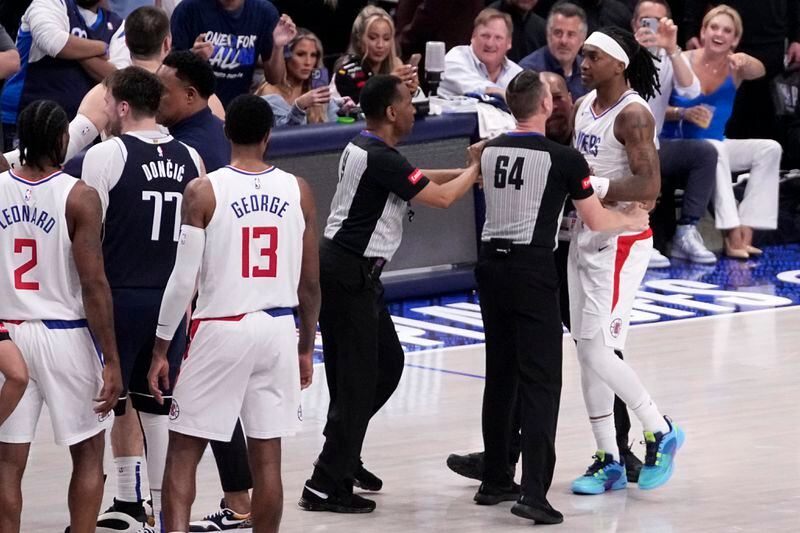 Los Angeles Clippers' Terance Mann, right, is held back, by referee Justin Van Duyne (64), after an altercation with Dallas Mavericks during the second half of Game 2 of an NBA basketball first-round playoff series in Dallas, Friday, April 26, 2024. AP Photo/Tony Gutierrez)