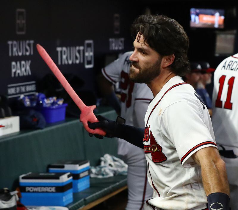 Braves shortstop Dansby Swanson chops the sword in the dugout after hitting a solo homer to start the rally during the ninth inning to beat the San Francisco Giants 4-3 in a MLB baseball game on Wednesday, June 22, 2022, in Atlanta.     “Curtis Compton / Curtis.Compton@ajc.com”