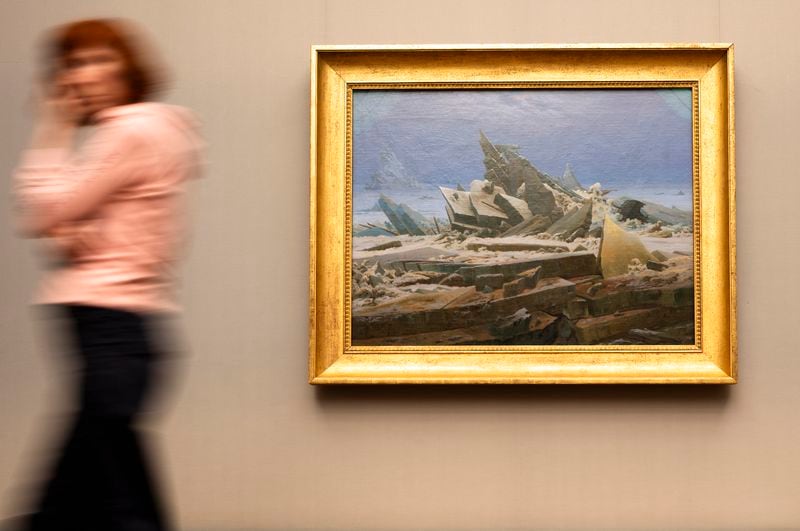 A woman walks near Caspar David Friedrich's painting 'The Sea of Ice' during a press preview of the exhibition 'Caspar David Friedrich. Infinite Landscapes' at the Alte Nationalgalerie museum in Berlin, Wednesday, April 17, 2024. The exhibition marking the 250th birthday of Caspar David Friedrich and will run from April 19 until August 4, 2024. (AP Photo/Markus Schreiber)