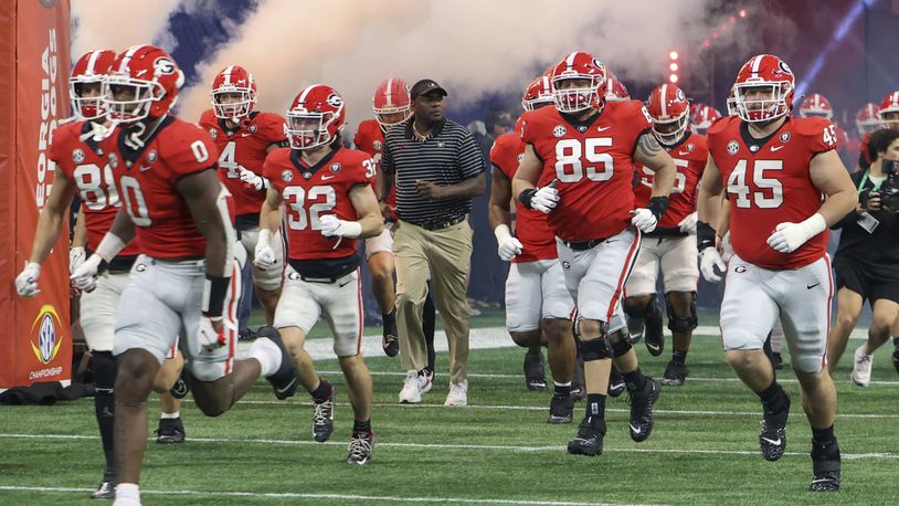 Bryant Gantt runs onto the field with Georgia Bulldog players before the SEC championship game on Dec. 3. Gantt, the team's director of player support and operations, alerted Athens police chief Jerry Saulters that a fatal crash in January involved UGA football players.  After the call, the chief cleared Gantt’s access to officers at the scene of the wreck. (Jason Getz / Jason.Getz@ajc.com)