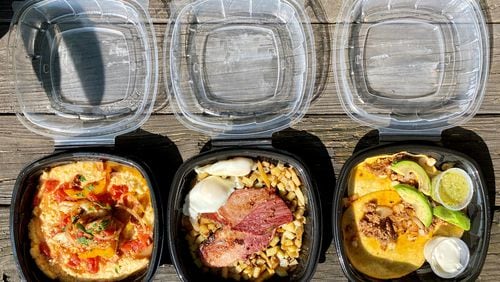 This takeout order from Hot Betty’s in Tucker includes fish and grits, corned beef brisket hash with poached eggs, and breakfast tacos with chorizo, onion and hominy. Wendell Brock for The Atlanta Journal-Constitution