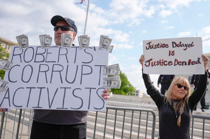 Demonstrates stand outside the Supreme Court as the justices prepare to hear arguments over whether Donald Trump is immune from prosecution in a case charging him with plotting to overturn the results of the 2020 presidential election, on Capitol Hill Thursday, April 25, 2024, in Washington. (AP Photo/Mariam Zuhaib)