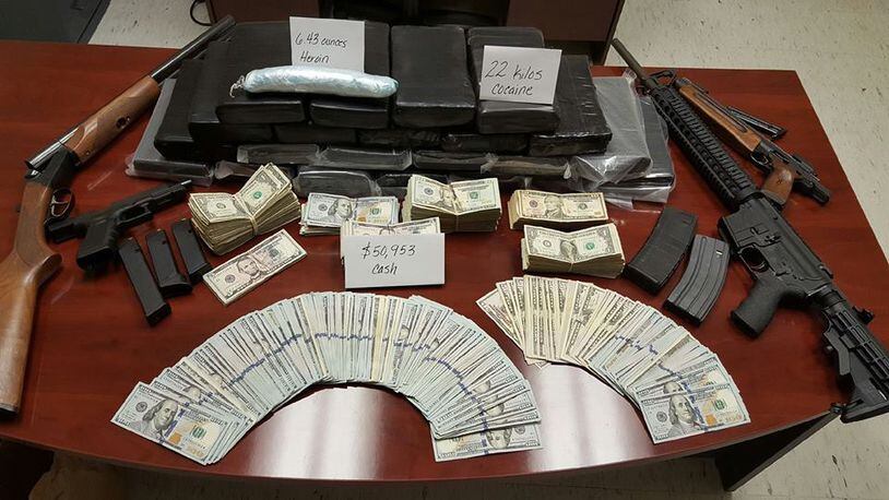 During arrests at multiple Rockdale County residences on Tuesday, agents recovered 22 kilos of cocaine, more than six ounces of heroin, $50,953 cash, multiple firearms and two vehicles with hidden compartments used to traffic drugs, the sheriff’s office said. (Credit: Rockdale County Sheriff’s Office)