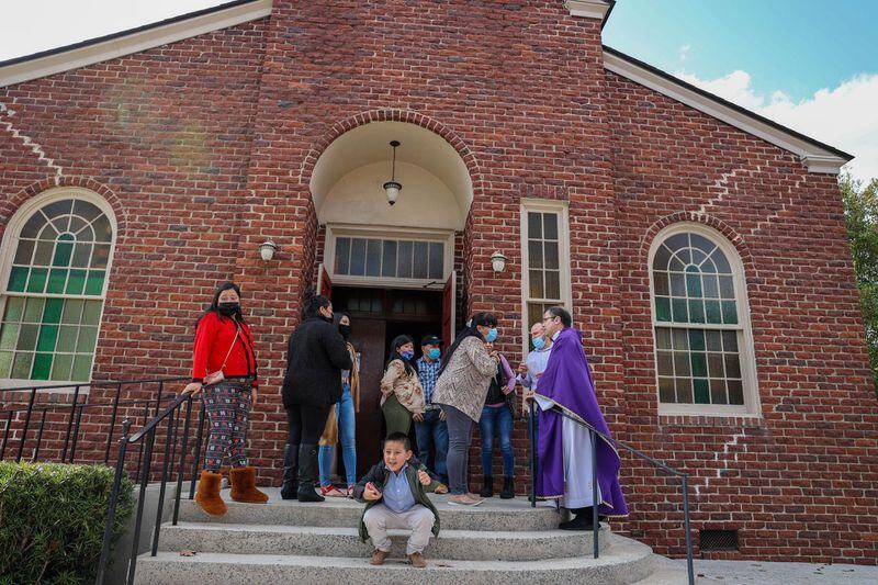 Parishioners talk with Father Pablo Migone following Sunday service at Our Lady of Lourdes Catholic Church in Port Wentworth.