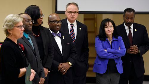 All DeKalb County commissioners stand during a statement of proclamations during a regular meeting on Tuesday. From left are Commissioners Kathie Gannon, Larry Johnson, Mereda Davis Johnson, Greg Adams, Jeff Rader, Nancy Jester and Steve Bradshaw. (DAVID BARNES / DAVID.BARNES@AJC.COM)
