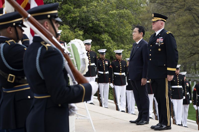 Japan's Prime Minister Fumio Kishida, with Commanding General Military District of Washington Maj. Gen. Trevor Bredenkamp, right, stands at attention during a wreath laying ceremony at the Tomb of the Unknown Soldier, at Arlington National Cemetery, in Arlington, Va., Tuesday, April 9, 2024. (AP Photo/Manuel Balce Ceneta)