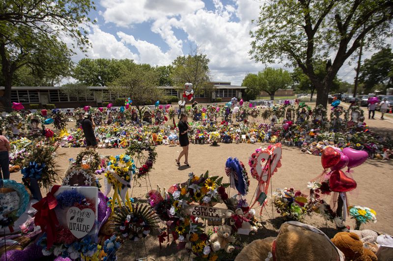 Part of a large makeshift memorial to the victims of a May 24 mass shooting at Robb Elementary School, where 19 students and two teachers were killed, in Uvalde, Texas, is shown on June 3, 2022. Heavily armed officers delayed confronting the gunman for more than an hour despite supervisors at the scene being told that some trapped with him in two classrooms were in need of medical treatment, a new review of video footage and other investigative material shows. (Ivan Pierre Aguirre/The New York Times)