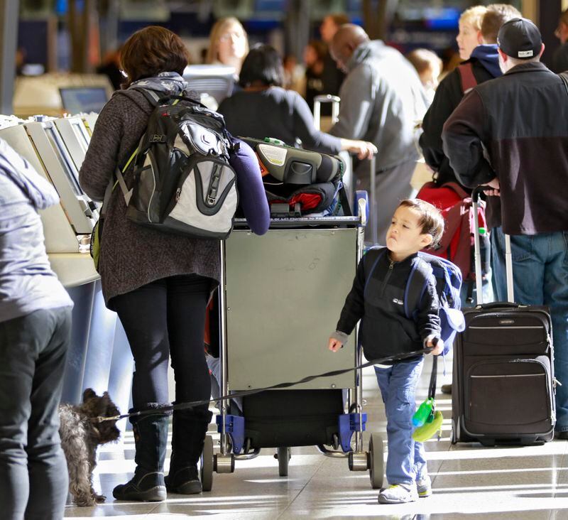 Nov. 20, 2015 - Atlanta - Kellan Trawny, 5, from Smyrna, keeps watch on the family dog while his mom checks in at the Delta Kiosk. Record crowds are expected along with long lines and delays at Hartsfield-Jackson Atlanta International Airport, the world's busiest airport, which is forecasting some of the biggest increases in traffic it has seen in years. BOB ANDRES / BANDRES@AJC.COM