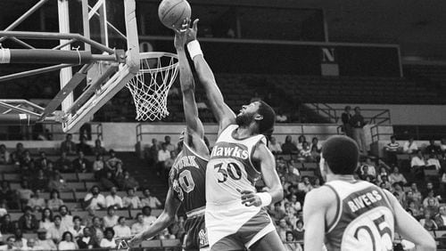 New York Knicks' Bernard King (30), left, has his shot blocked by Tree Rollins (30), right, of the Atlanta Hawks during first period action in New Orleans, La., Dec. 26, 1984. (AP Photo/Andrew J. Cohcon)