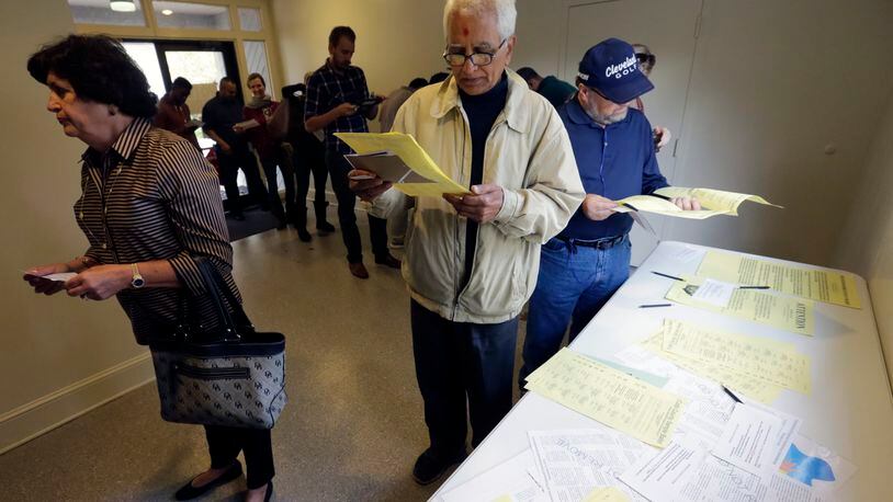 Manubhai Patel looks over the Cobb County ballot as he waits in line to vote. The line was long but moved quickly as voters lined up to at the Life Church Smyrna Assembly of God on Tuesday. BOB ANDRES /BANDRES@AJC.COM