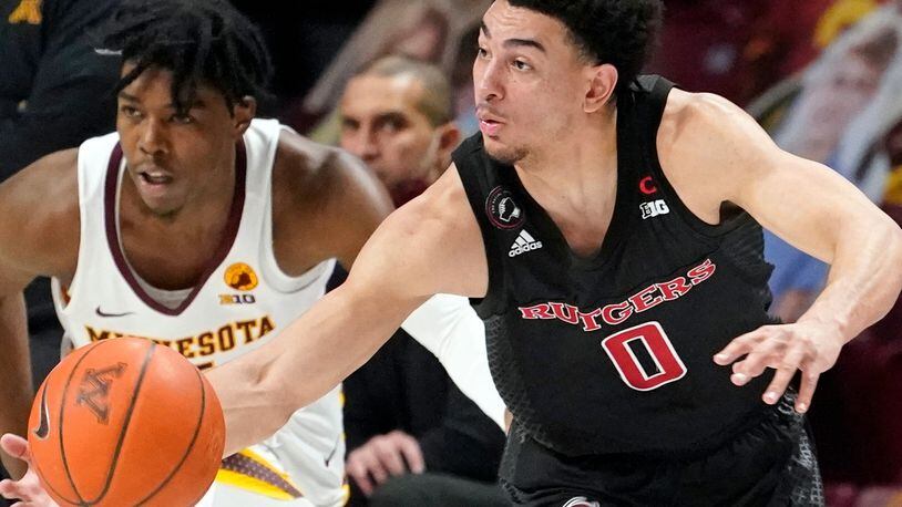 Rutgers' Geo Baker (0) drives as Minnesota's Marcus Carr (5) chases in the second half of an NCAA college basketball game, Saturday, March 6, 2021, in Minneapolis. Rutgers won 77-70. (AP Photo/Jim Mone)