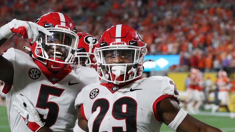 Georgia defensive back Christopher Smith (right) strikes a pose alongside teammate Kelee Ringo after intercepting a pass against Clemson and returning it 74 yards for a touchdown in the second quarter of what ended as a 10-3 win over the No. 3-ranked Tigers in the Dukes Mayo Classic in Charlotte on Sept. 4, 2021. (Photo by Curtis Compton/ccompton@ajc.com)