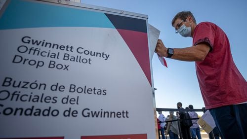 A voter places his absentee ballot inside a drop box on the second day of early voting at the Gwinnett County Voter Registration and Elections building on Oct. 13, 2020, in Lawrenceville, Georgia. An auditor from Gwinnett County, Mark Andrews, who was falsely accused of election fraud in the film "2000 Mules" later filed a defamation lawsuit against the movies makers, Dinesh D'Souza and True the Vote, alleging they lied to advance a phony narrative at his expense. (File photo by Alyssa Pointer/Atlanta Journal-Constitution/TNS)