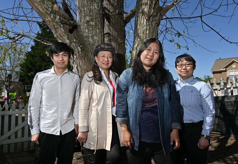 Jing Su (center right) is starting a nonprofit called Help & Heal to help those affected by violence and trauma. She's joined (from left) by Jack Wongtam, secretary; Jing Zheng, volunteer; and Ambrose Xie, CFO, during a photo shoot at Su's home in Suwanee on Thursday, April 1, 2021. (Hyosub Shin / Hyosub.Shin@ajc.com)