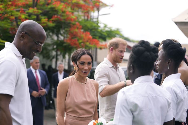 Prince Harry and Meghan meet children at the Lights Academy in Abuja, Nigeria, Friday, May 10, 2024. Prince Harry and his wife Meghan have arrived in Nigeria to champion the Invictus Games, which he founded to aid the rehabilitation of wounded and sick servicemembers and veterans. (AP Photo/Sunday Alamba)