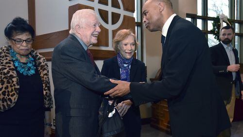 Former President Jimmy Carter is greeted by Tommy Amaker (right), head coach of Harvard men's basketball team, before a Sunday service at historic Ebenezer Baptist Church. HYOSUB SHIN / HSHIN@AJC.COM